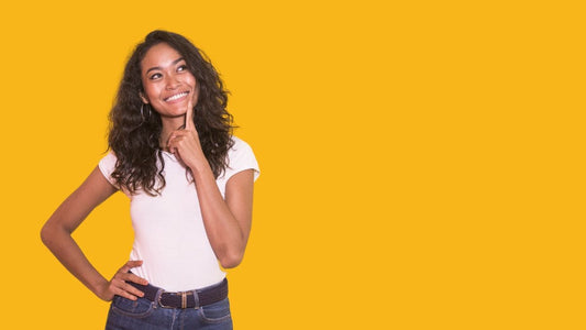 Woman with long dark hair looking up with a smile and a sunny yellow background