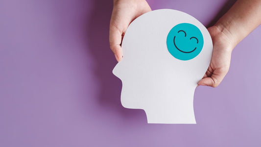 Child hands holding a white model of a head that has a happy face where the brain should be