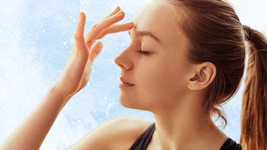 Woman pressing her finger to the yintang point of her forehead