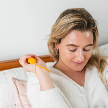 woman holding chill pill in bed