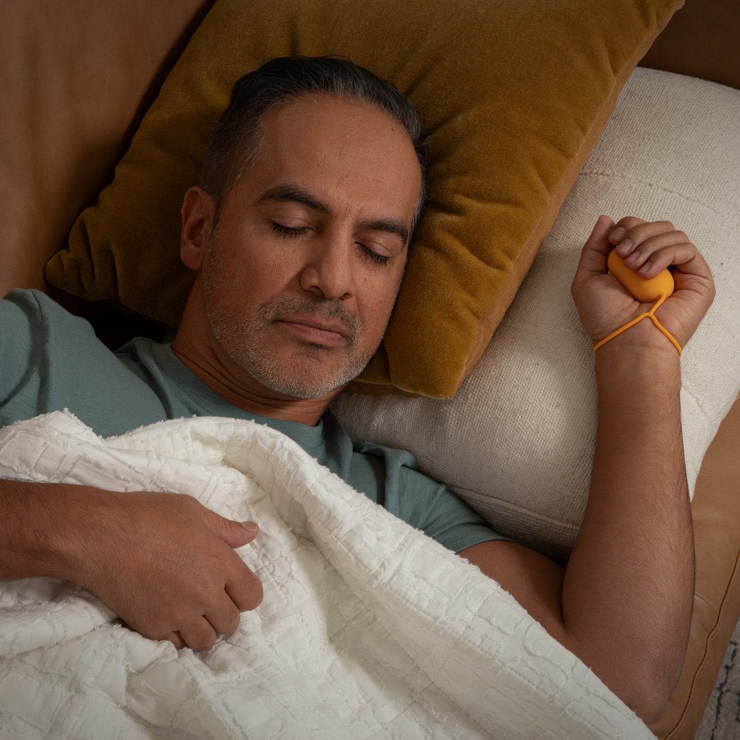 Man using Chill Pill handheld microcurrent device for sleep